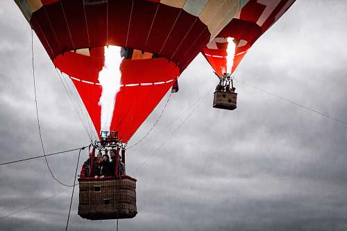 hot air balloon people on red and beige air balloons triangle